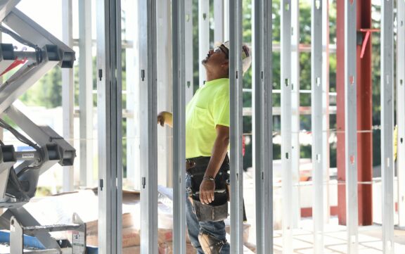 An image of a male worker on a construction site looking upwards inspecting the structure