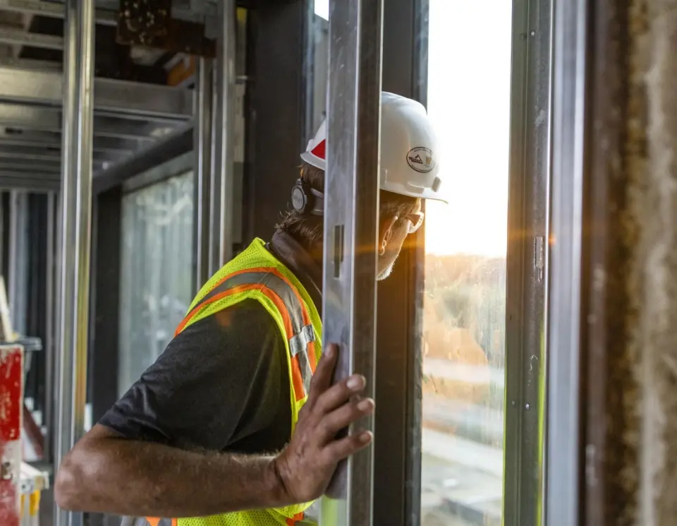 An image of a worker looking through an open window